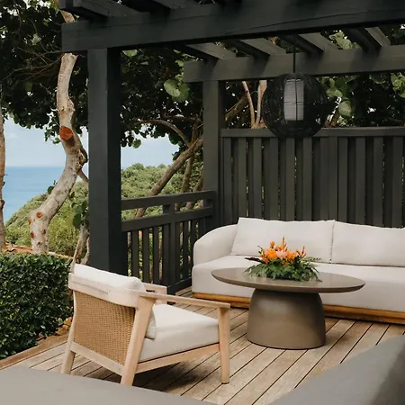 Royal Isabela Hotel Exterior photo This is a photograph of a stylish outdoor lounge area, suggesting a sophisticated retreat or high-end patio.

The area is defined by a dark, wooden pergola structure, which provides a modern, architectural framework to the space. Underneath the pergo