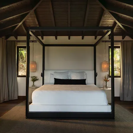 Royal Isabela Hotel Exterior photo This is a photo of a luxurious and rustic master bedroom.

The room has a warm, earthy ambiance, featuring a high, vaulted ceiling with visible dark wooden beams, giving it a natural, almost tropical or lodge-like feel. The flooring is dark wood, con