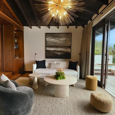 Royal Isabela Hotel Exterior photo This is a photo of a modern, luxurious, and airy living room with a beautiful connection to the outdoors.

**Key Features:**

*   **Seating Area:** The center features a comfortable, contemporary white sofa dressed with dark throw pillows. In front o