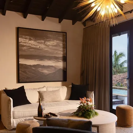Royal Isabela Hotel Exterior photo This is an image of a modern and well-decorated interior space, likely a living room or hotel suite.

**Here's a detailed description:**

*   **Artwork:** The most prominent feature is a large, horizontal piece of artwork hanging on the wall. It appe