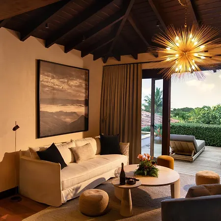 Royal Isabela Hotel Exterior photo This is a photo of a luxurious and warmly lit modern living space with an open connection to the outdoors.

**Interior Features:**
*   **Ceiling:** The room has a striking, high, vaulted wooden ceiling, giving it a rustic yet upscale feel.
*   **Ligh