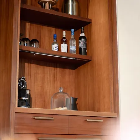 Royal Isabela Hotel Exterior photo This is a photo of a built-in wooden shelving unit, likely used for display or storage.

The shelving unit has a warm, medium-brown wood finish. The upper shelves are visible, and on them, there are several bottles lined up:
*   On the left, there ar