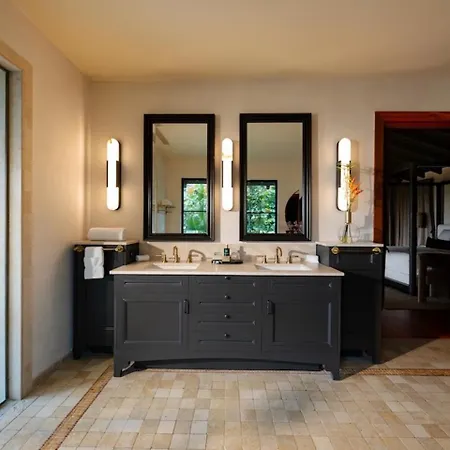 Royal Isabela Hotel Exterior photo This is a photo of a modern and stylish bathroom.

The room features a large, dark-colored vanity with a countertop, which appears to be made of light-colored marble or stone. Sitting atop the vanity are two sinks. Above the vanity, there are two rec