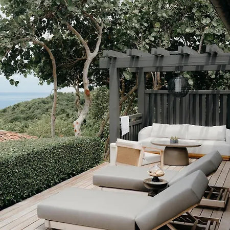 Royal Isabela Hotel Exterior photo This is a serene and luxurious outdoor scene, likely from a high-end resort or private villa.

In the foreground, there is a modern outdoor living area set on a wooden deck. The area features comfortable, contemporary lounge furniture in neutral tone